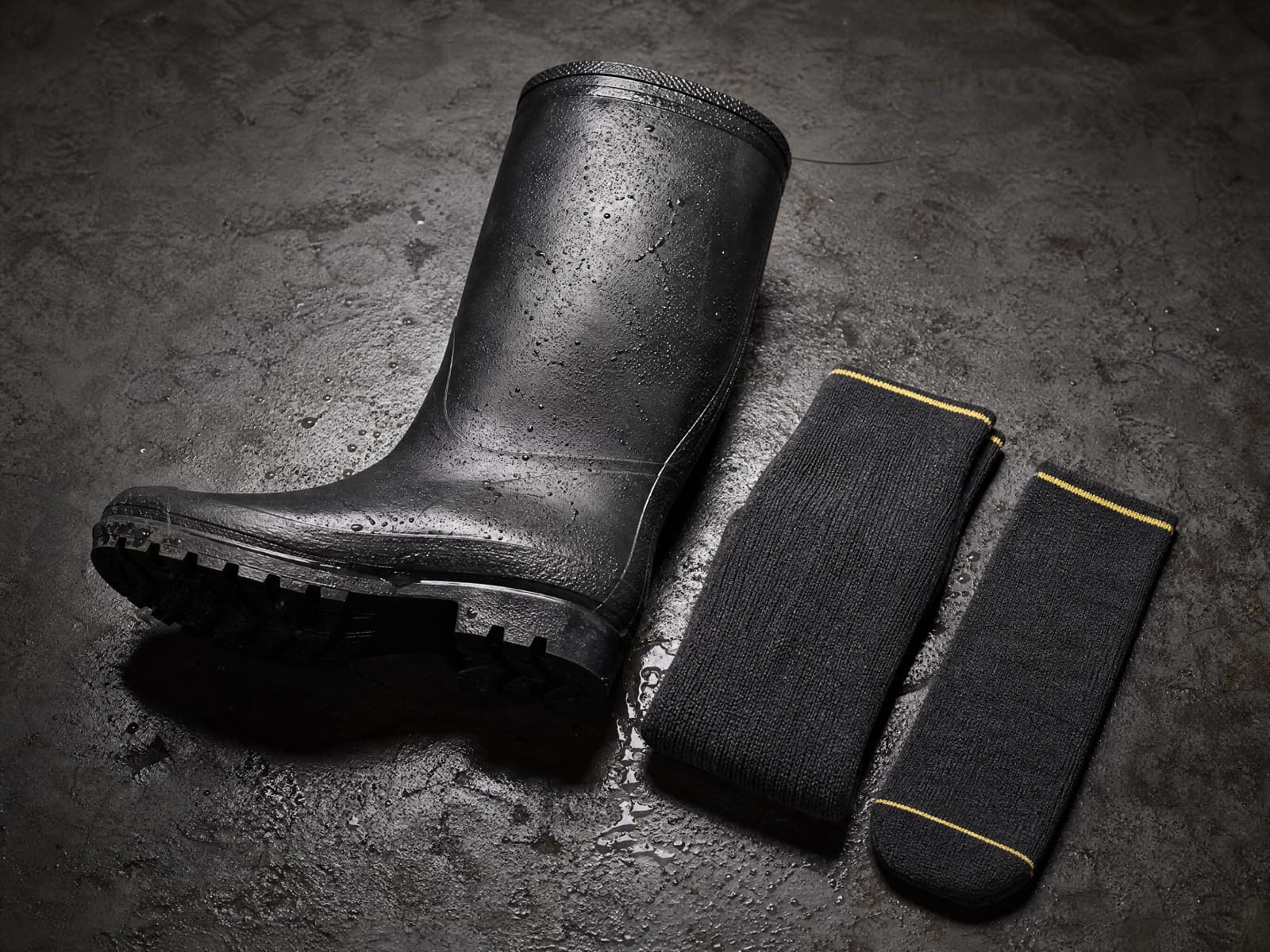 Rubber boot shown beside an Onshift sock on a workbench